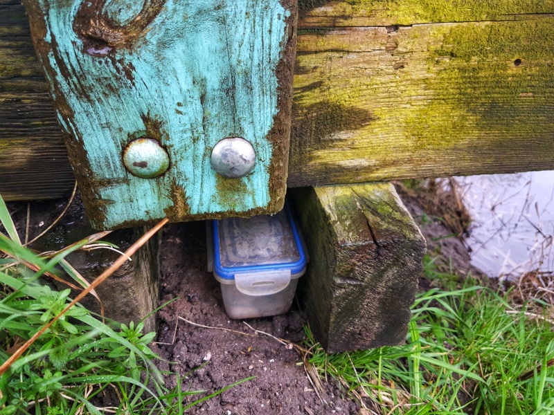 Geocaching box under a small wood bridge